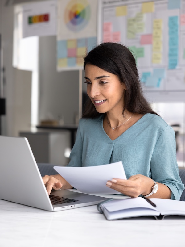 Accountant checking electronic and paper financial reports